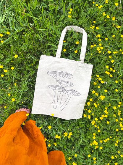 Girl looking down at Keep it Shroomy tote in flowers