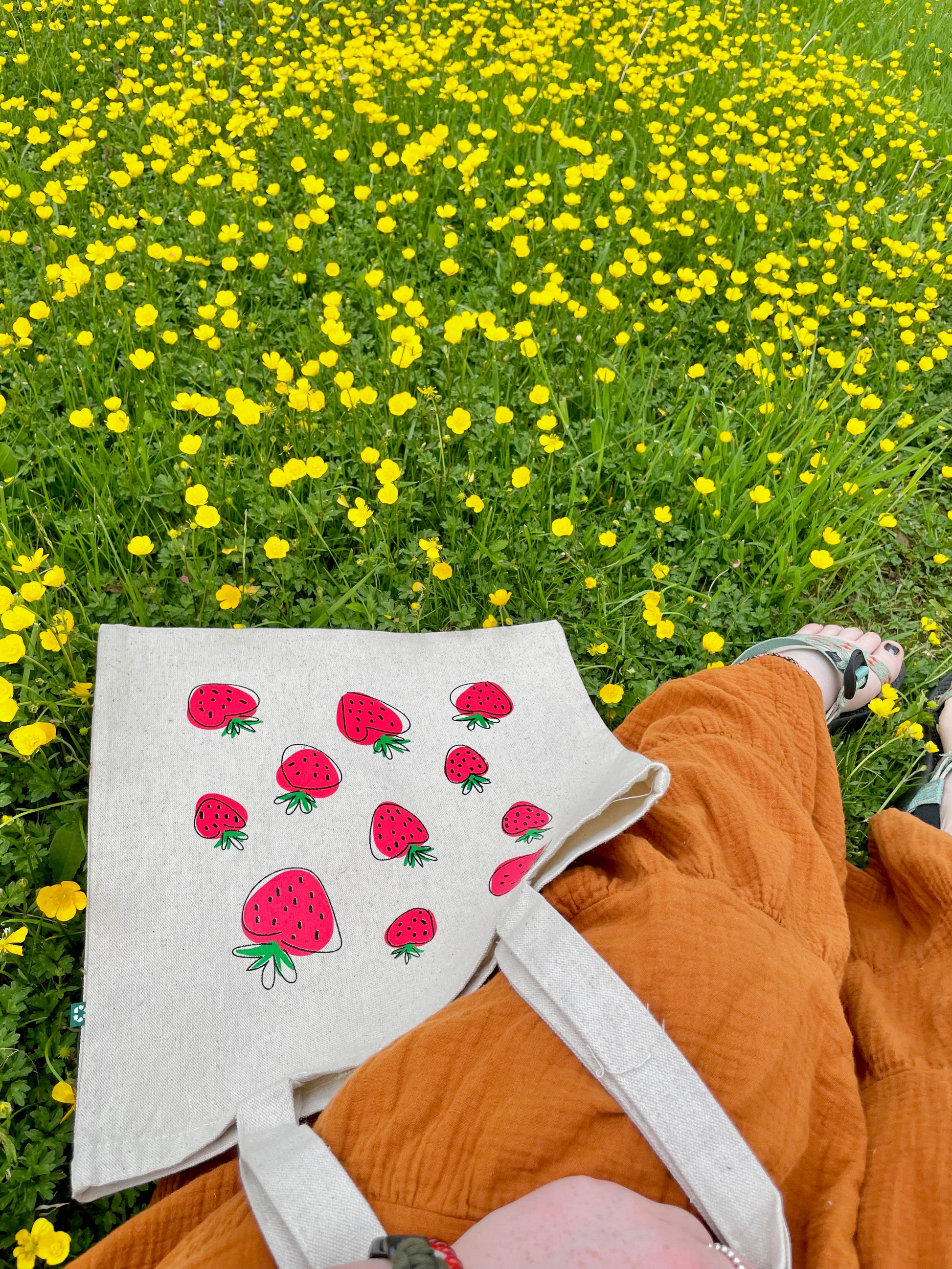 Girl sitting with Super Berry tote looking at flowers