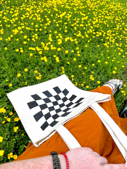 Girl sitting in flowers with Dazed and Confused tote in lap