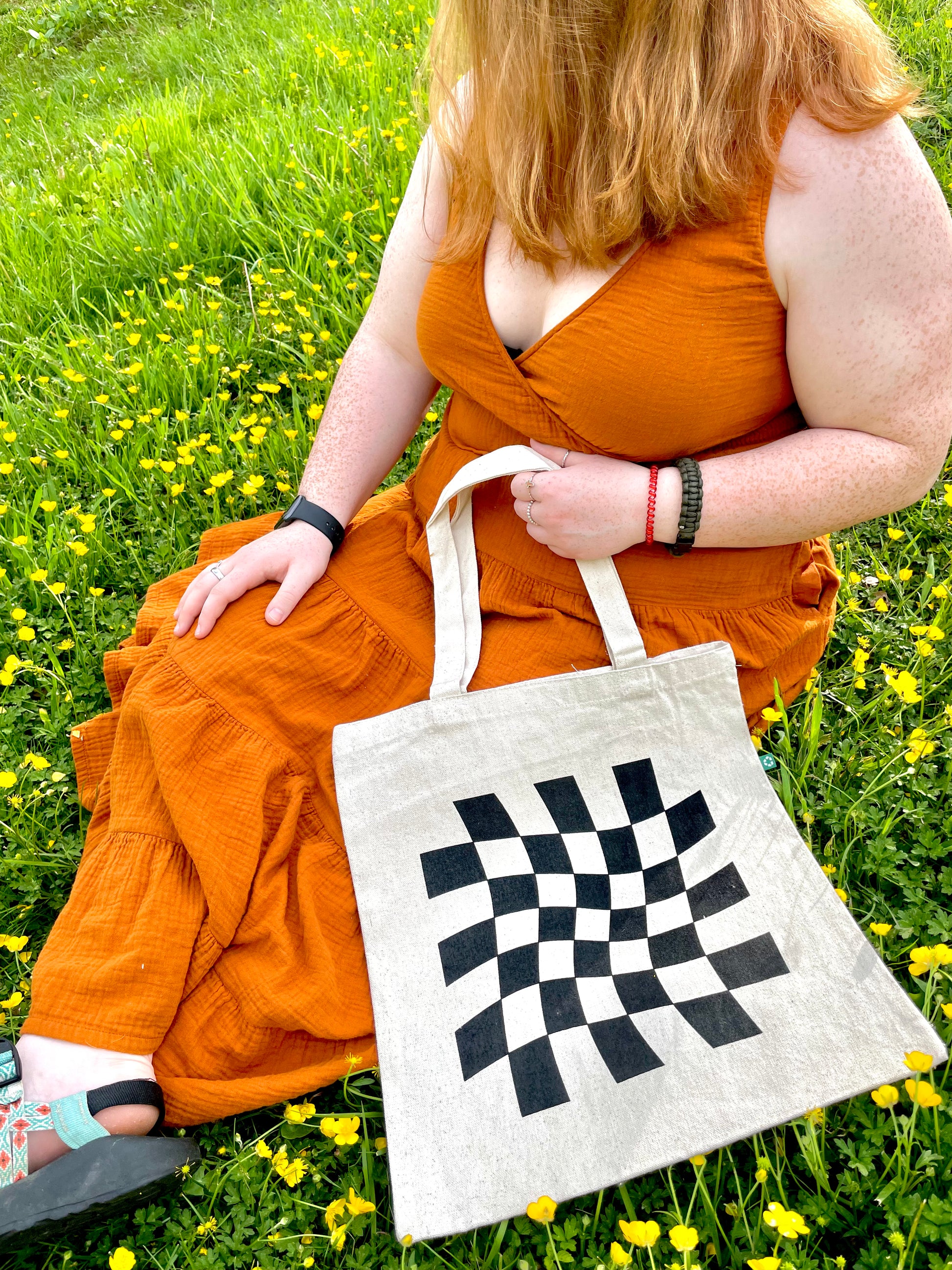 Girl sitting with Dazed and Confused tote in flowers