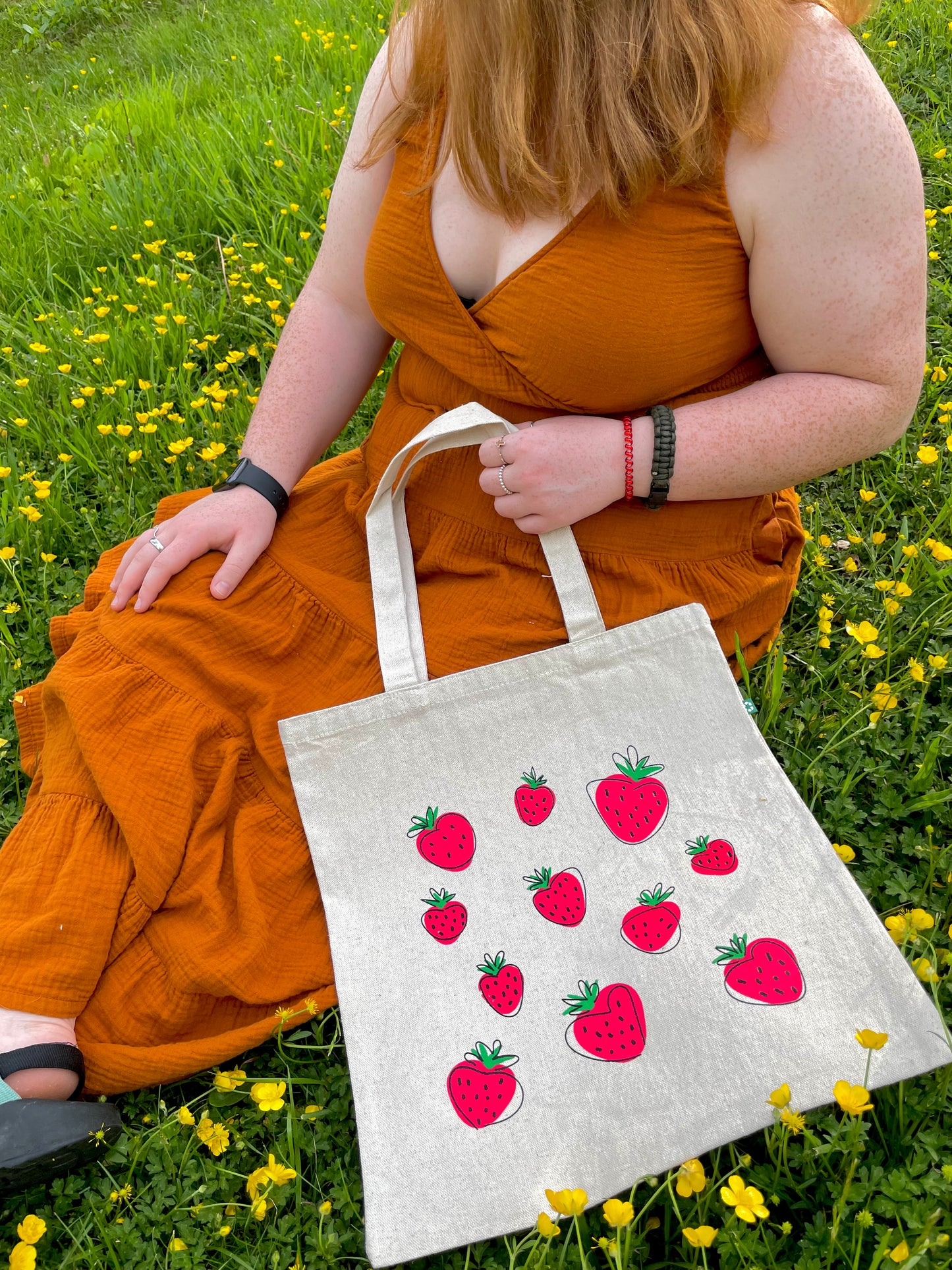 Girl sitting in flowers with Super Berry tote in lap