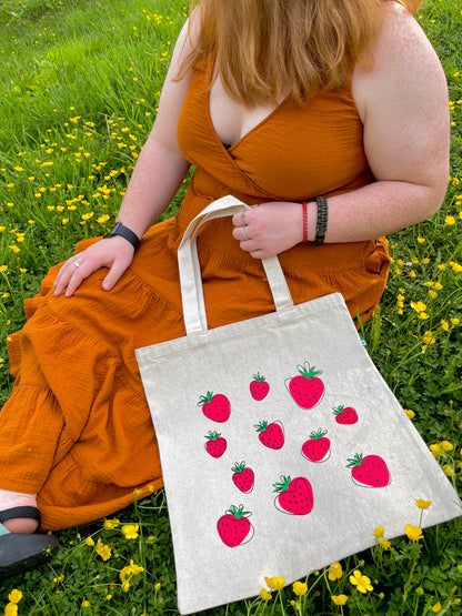 Girl sitting in flowers with Super Berry tote in lap