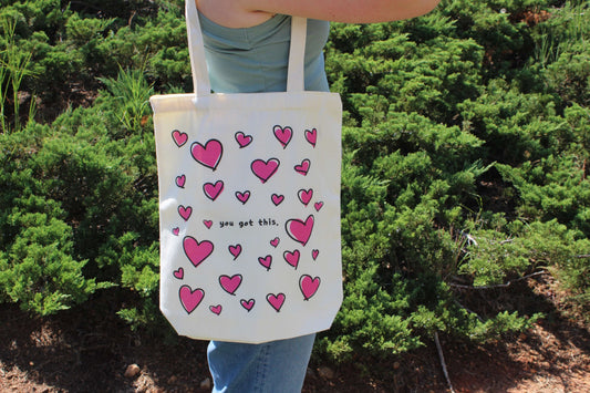 Girl holding Lots of Love tote outside over shoulder