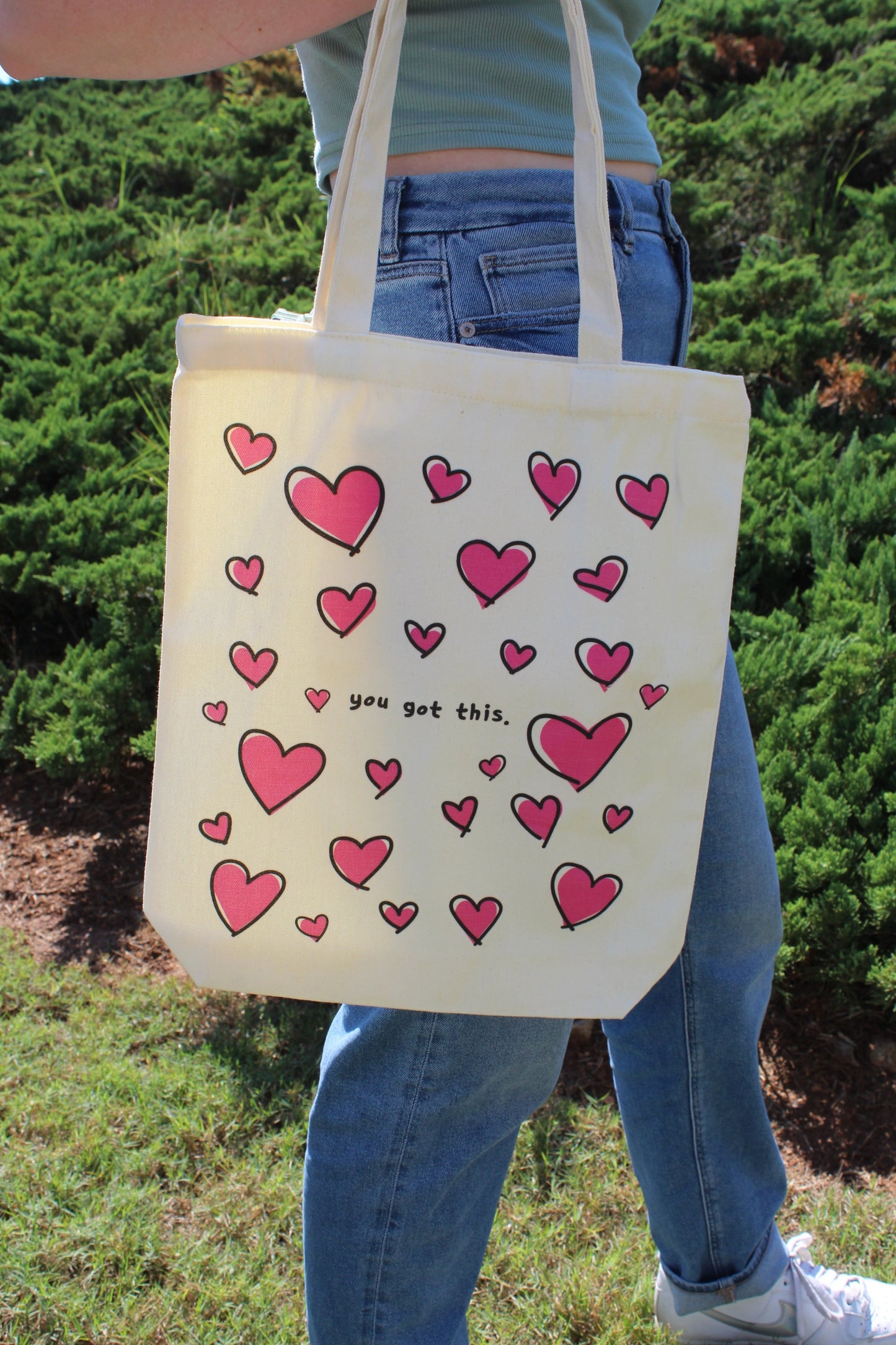 Girl holding Lots of Love tote outside by side