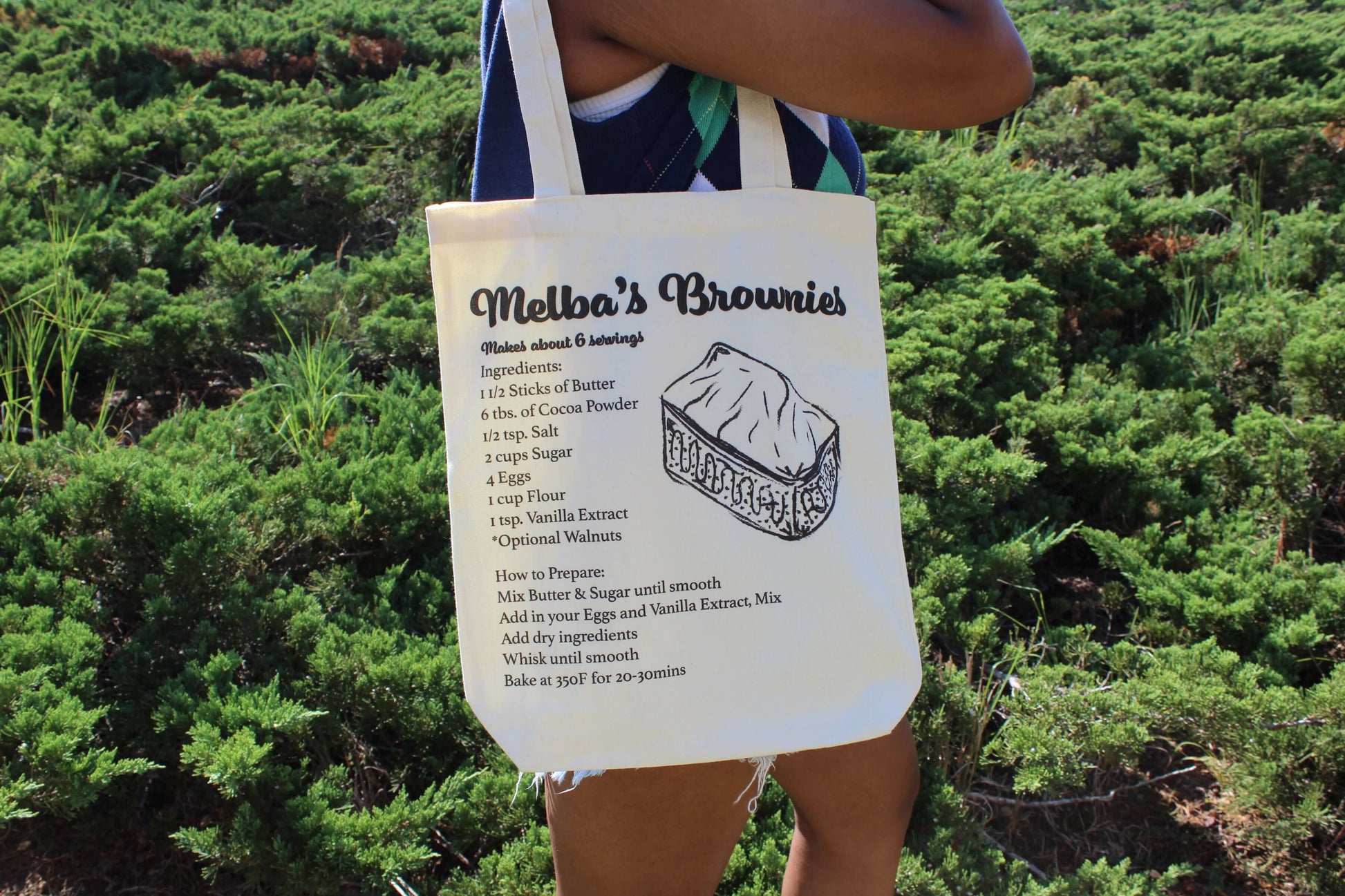 Girl holding Melba's Brownies tote over shoulder by her side