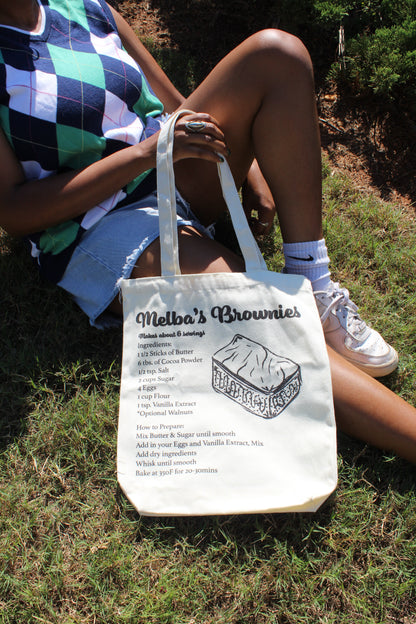 Girl sitting outside with Melba's Brownies tote in lap