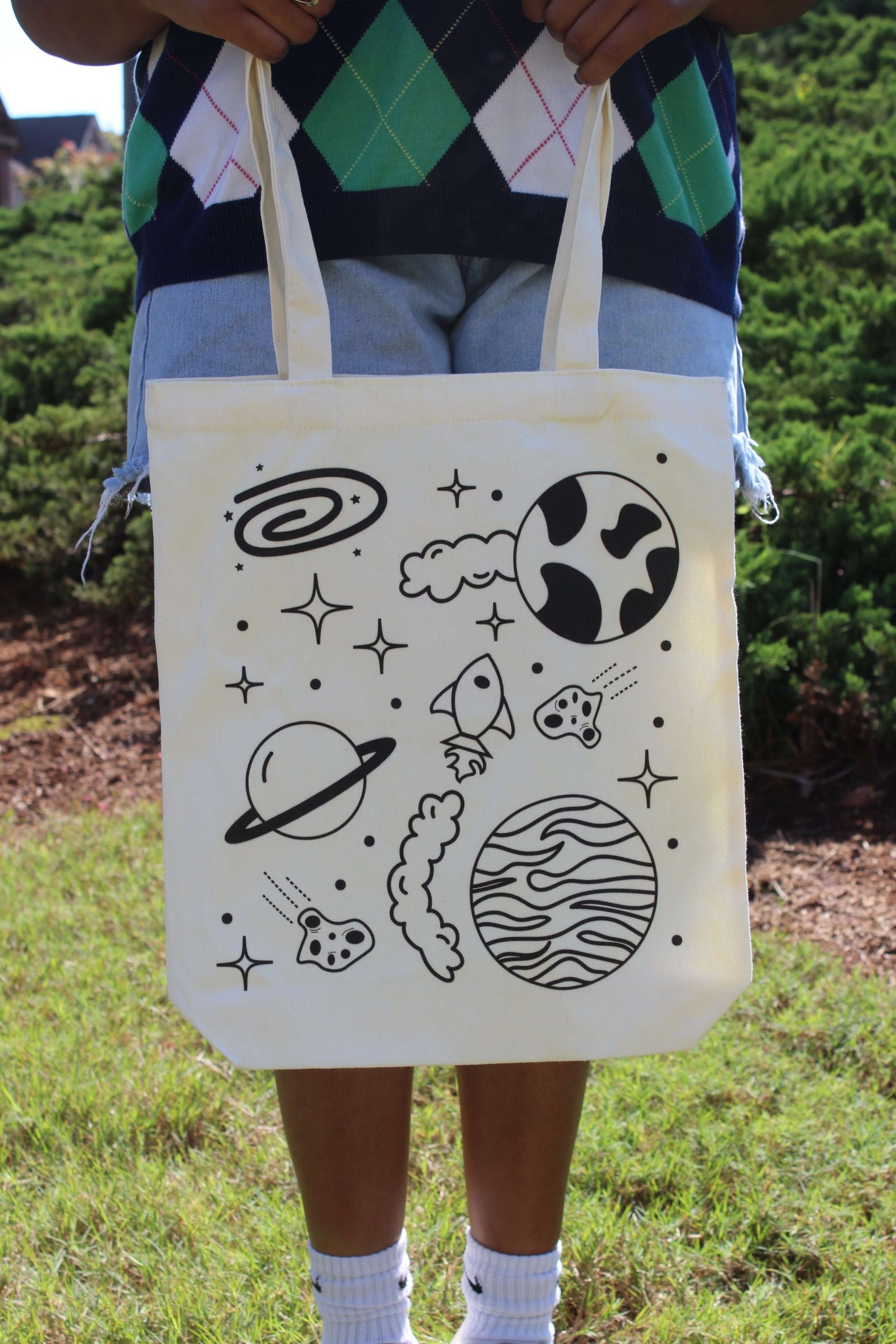 Girl holding Spaced Out tote in front of body with two hands