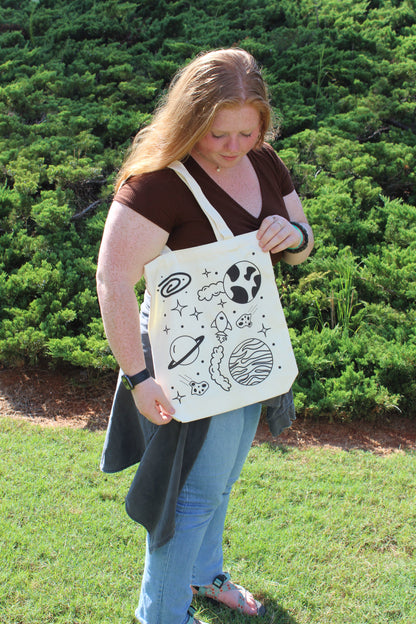 Girl looking down at Spaced Out tote over shoulder