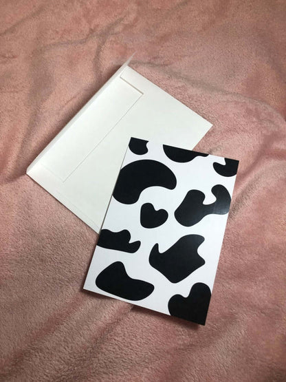 Cow print postcard with envelope with wood background