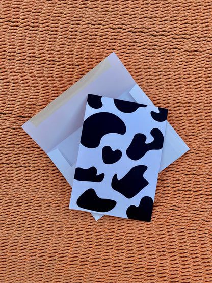 Cow print postcard with envelope with wood background