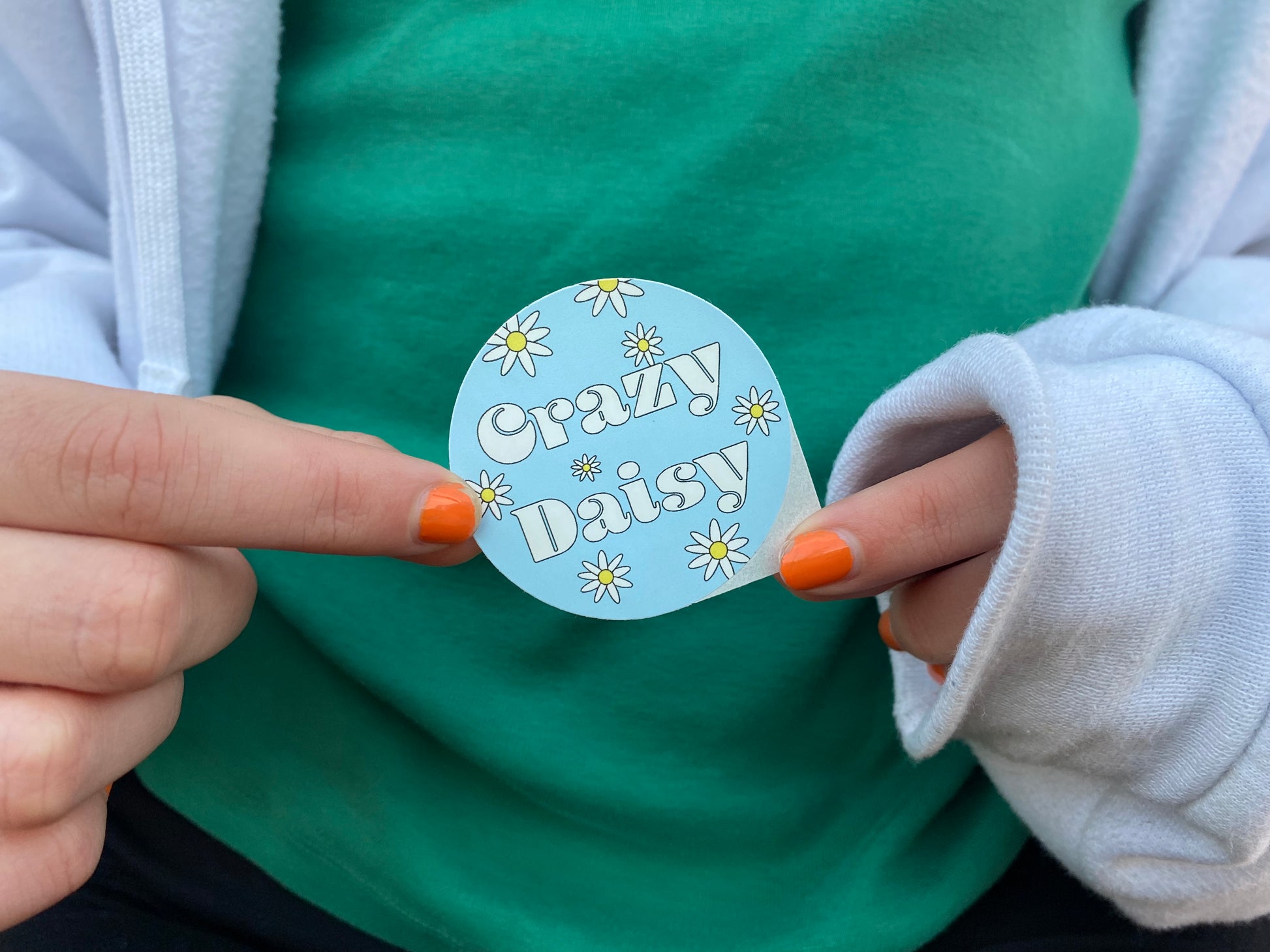 Girl holding Crazy Daisy sticker in front of her