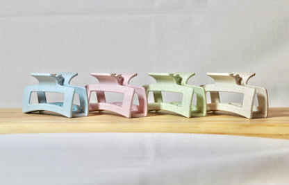 Four different colored claw clips in a side line