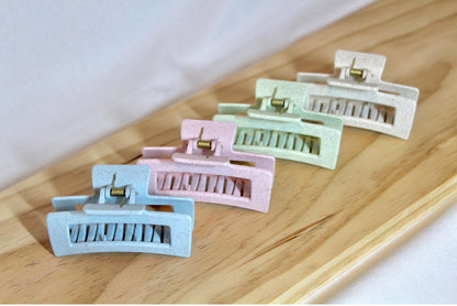 Overhead look at four different colored claw clips in a row